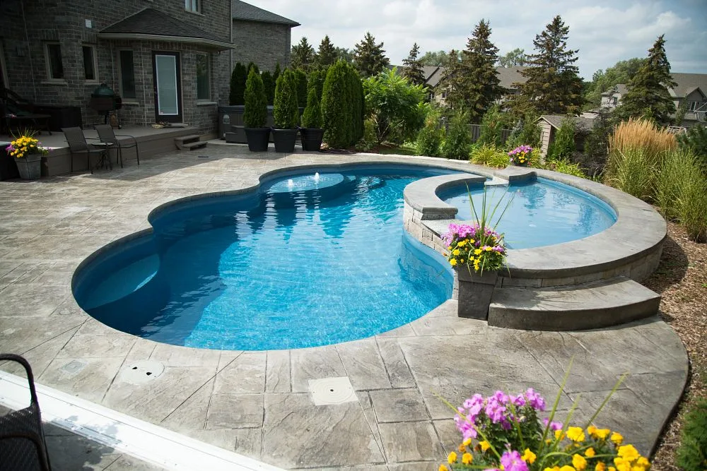 Fiberglass in-ground pool with tan ledge